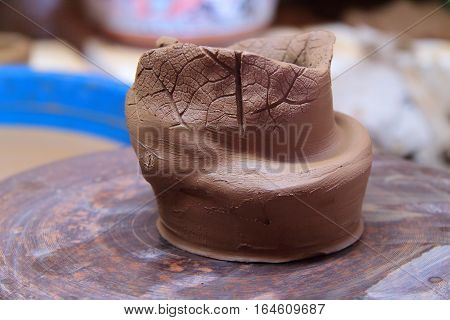 A clay pot on a pottery wheel, pottery craft, moulding the pot with your hands, sculpting hands