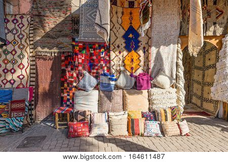Marrakesh Morocco - December 8 2016: Textiles for sale in the famous souks of Marrakesh Morocco Africa. The sun's rays on the carpets.