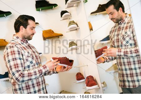 adult man shopping for shoes in a fashion store