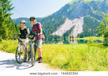 A senior couple is taking a break by the lakeside.