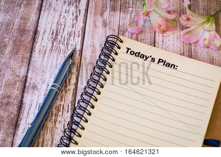 Today's Plan motivational concept with notebook and pen on wooden board