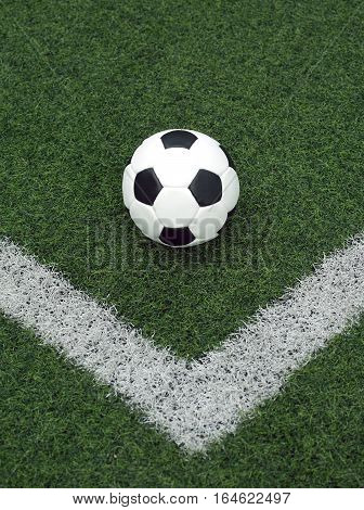 White and black ball for playing soccer in corner  line on synthetic grass  close-up