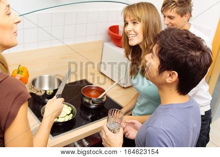 Group of friends cooking together at home.