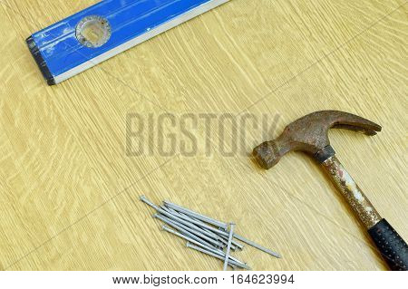 Hammer, nails and sprit level on the table with copy space.