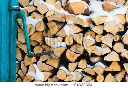 Stacked firewood in winter under the snow. Stock photo