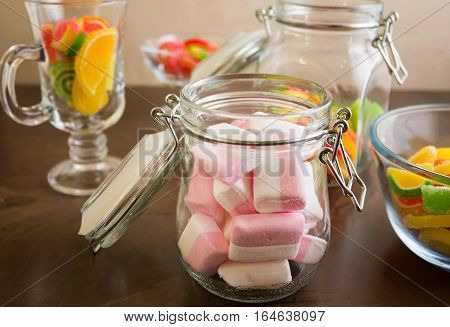 Marshmallow in a glass jar and marmalade. Delicious sweets.
