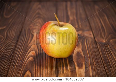 red and yellow apples on a wooden table