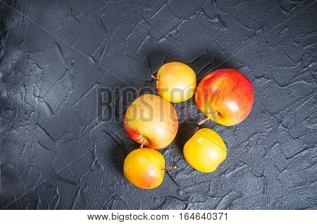 red and yellow apples on a black table
