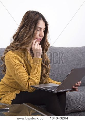 Woman sitting in home working with her laptop