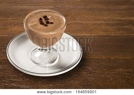 Coffee cream pannacotta selective focus on wooden background.