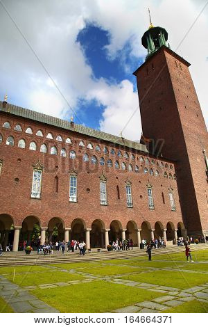 STOCKHOLM SWEDEN - AUGUST 19 2016: Tourists walk and visit Stockholm City Hall ( Stadshuset ) Venetian-style colonnade that divides the City Hall in Stockholm Sweden on August 19 2016.