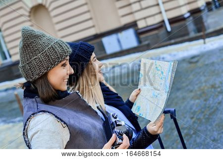 Two friends tourists choose attractions on the paper map