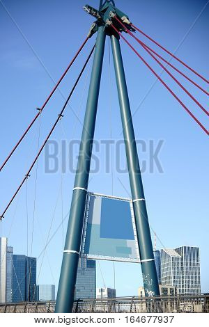 The bridge pillar or A-shaped pylon of the Holbeinsteg Bridge in Frankfurt in front of the Frankfurt skyline.