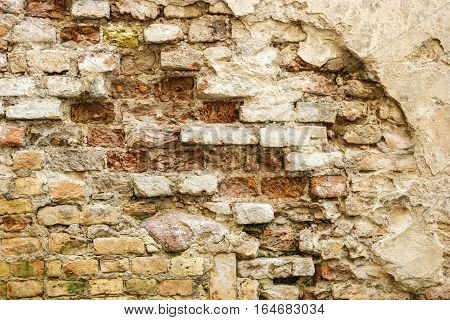 Damaged brick wall. Old bricks background. Centuries turned beauty into ruins.