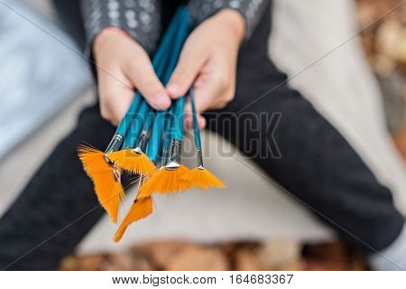 Young girl is holding colorful paint brushes