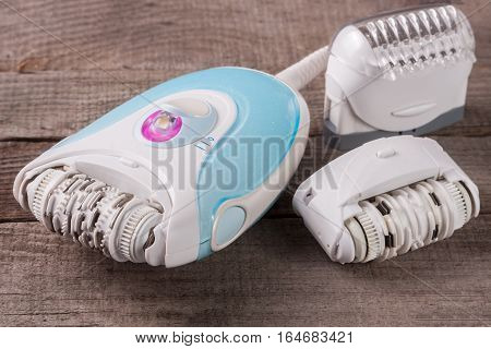 electric epilator on an old wooden background. Hair removal device