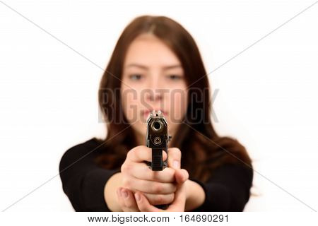 Close up young woman pointing a gun at the camera on white background