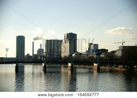 High-rise buildings like the Westhafen Tower as well as industry at the Peace Bridge and along the river Main in Frankfurt.