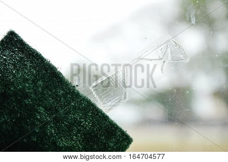 adhesive tape stain on window glass shield and scrub sponge