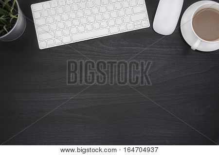 Black office desk table with computer flower and coffee cup Top view with copy space