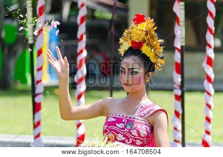 Bali Indonesia - 22 July 2016: A Balinese dancer performs a welcome dance throwing flowers in the air
