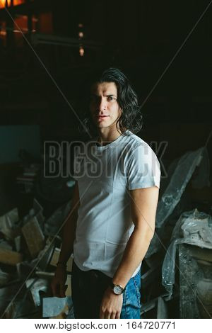 Beautiful long-haired brunette smiling man in a white T-shirt