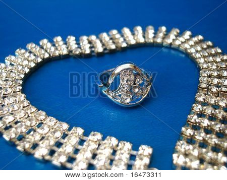 파란색 바탕에 반지와 다이아몬드 목걸이