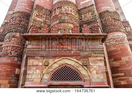 Islam Mosque and columns of Qutub Minar. Red sandstone. Verses from the Quran. Arabic script. Delhi India.