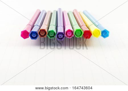 Colorful markers on white notebook - Office supplies