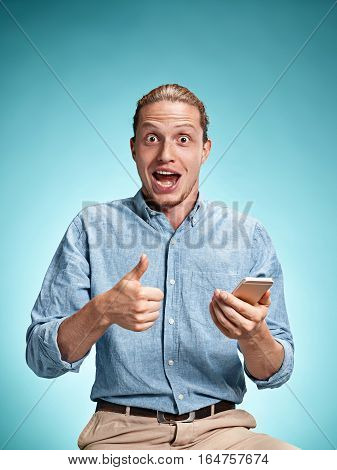 The Young Smiling Caucasian Man On Blue Background