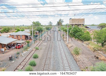 MODDERRIVIER SOUTH AFRICA - DECEMBER 25 2016: Houses and a reservoir next to the railroad at Modderrivier a village in the Northern Cape Province