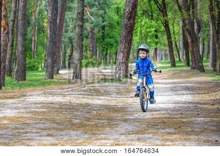 Happy Cute Blond Kid Boy Having Fun His First Bike On Sunny Summer Day, Outdoors.  Child Making Spor
