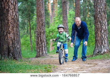 Happy Cute Blond Kid Boy Having Fun His First Bike On Sunny Summer Day, Outdoors.  Child Making Spor