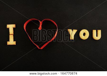 Text I heart you on black with red ribbon