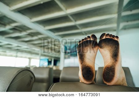 dirty feet. Legs in the soot on a chair on top. Women's heels in the soot on the net back of the chair.