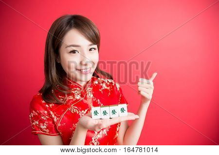 beauty woman thumb up and show mahjong to you in chinese new year - Rich and wealthy text on girl hand in Chinese words