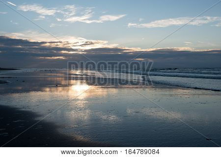 Sunset with reflection on the beach of Koksijde Belgium