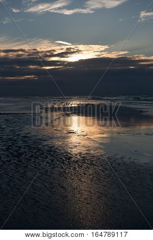Sunset with reflection on the beach of Koksijde Belgium