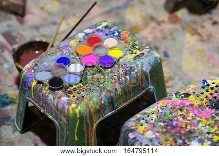 Art of Painting. Paint buckets on the chair background