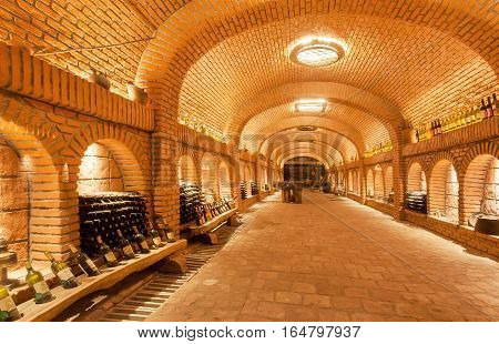 KVARELI, GEORGIA - OCT 3, 2016: Wine bottles waiting for tasting time inside huge cellar Khareba Winery with underground brick tunnel on October 3, 2016. The tunnel was opened in 1962 for the World Wine Congress