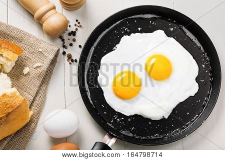 Fried eggs meal in a frying pan for delicious healthy breakfast. Traditional international breakfast food top view.