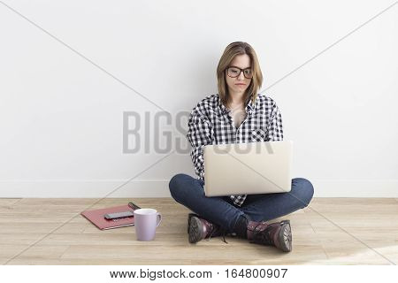 Young student working with computer in her room