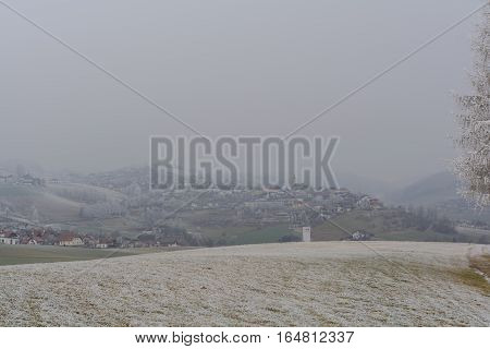 Hoarfrost covered winter landscape in the background fog shrouded village Peilstein - Austria