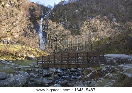 Bridge with river bellow and waterfall in the background, Winter landscape.