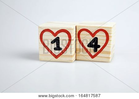 Wooden cubes with handwritten one and four inside red hearts. Valentine's day