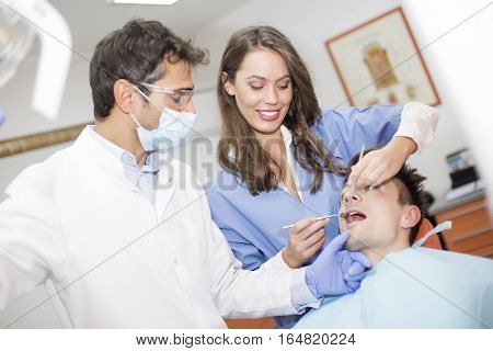 Young Man Having Dental Chekup At Dentist Office