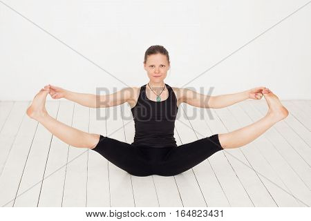 Slim white girl doing yoga exercise navasana
