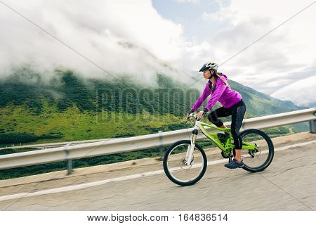 Young Woman Cycling. Shot taken in Switzerland, near Rhone Glacier and Furka Pass.