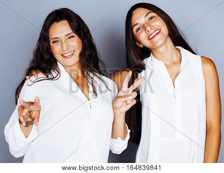 cute pretty teen daughter with mature mother hugging, fashion style brunette, lifestyle people concept close up