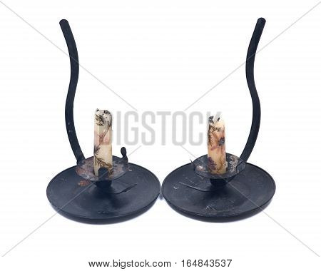 Natural bee wax candle in black vintage candle holder isolated on white background